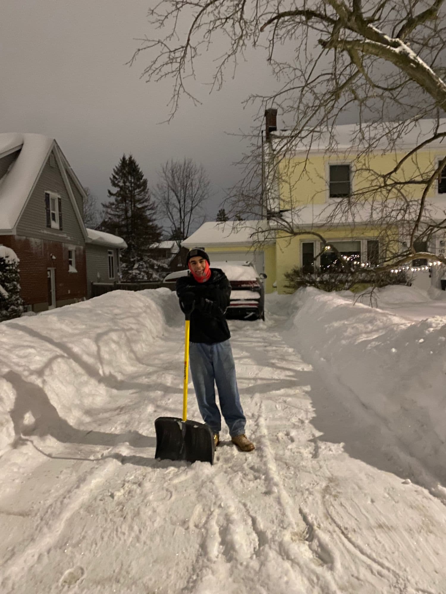 The same driveway fully cleared, with high banks of snow on either side.